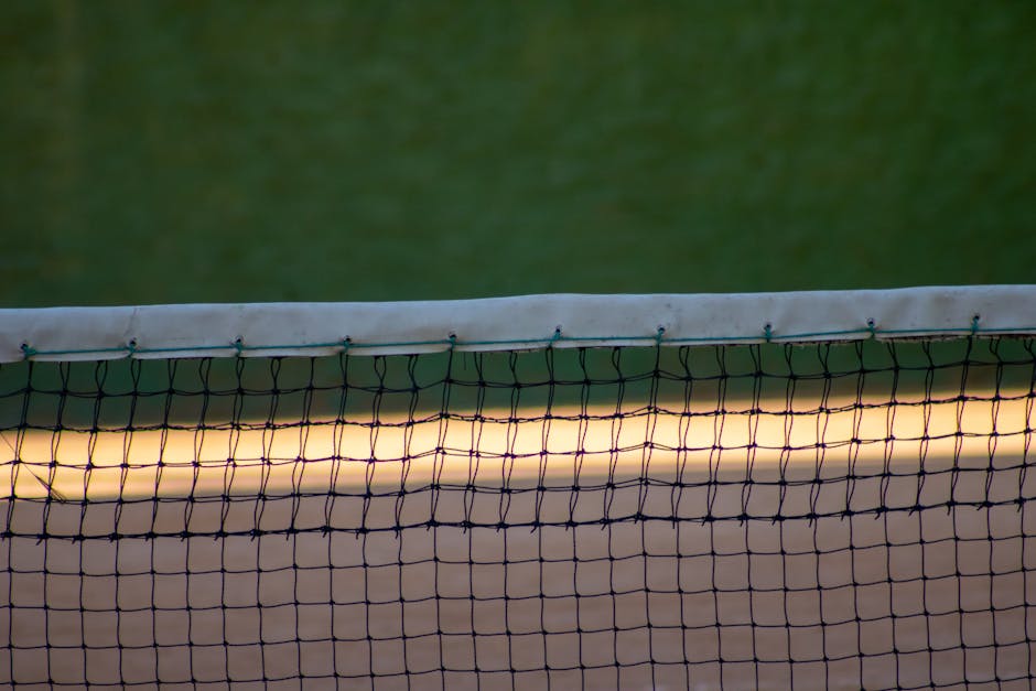 Seamless kaleidoscope wallpaper pattern — Geometry by wallpaper⁶ — base photo: A detailed view of a tennis court net at dusk with a green court background, showcasing sports equip