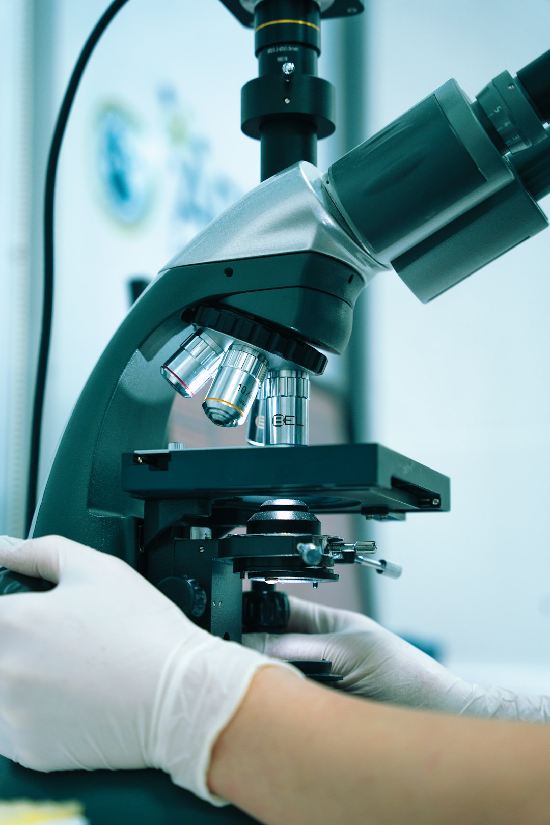 Seamless mirror wallpaper pattern — Medicine by wallpaper⁶ — base photo: a gloved hand operating a microscope in a laboratory