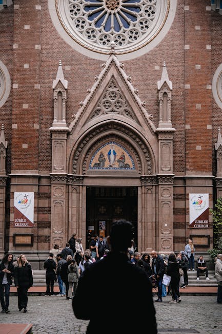 Gothic Window Hex pattern, a self-adhesive wallpaper featuring intricate geometric lines in a hexagonal repeat, inspired by Gothic architecture. — base photo: A striking Gothic church facade, bathed in natural light and bustling with visitors. The ornate ston