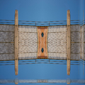 A mirrored geometric wallpaper pattern featuring red, blue, and yellow circles and lines on a cream background with Mirror symmetry.
