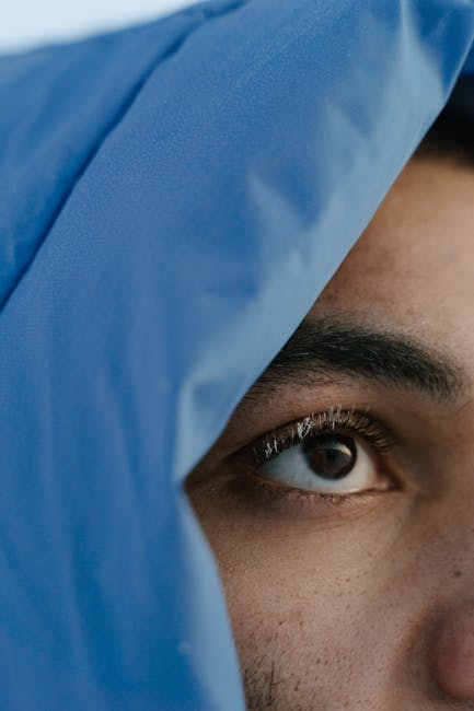 Seamless mirror wallpaper pattern — Medicine by wallpaper⁶ — base photo: A striking close-up of an eye partially covered by a blue hooded jacket, conveying mystery and focus