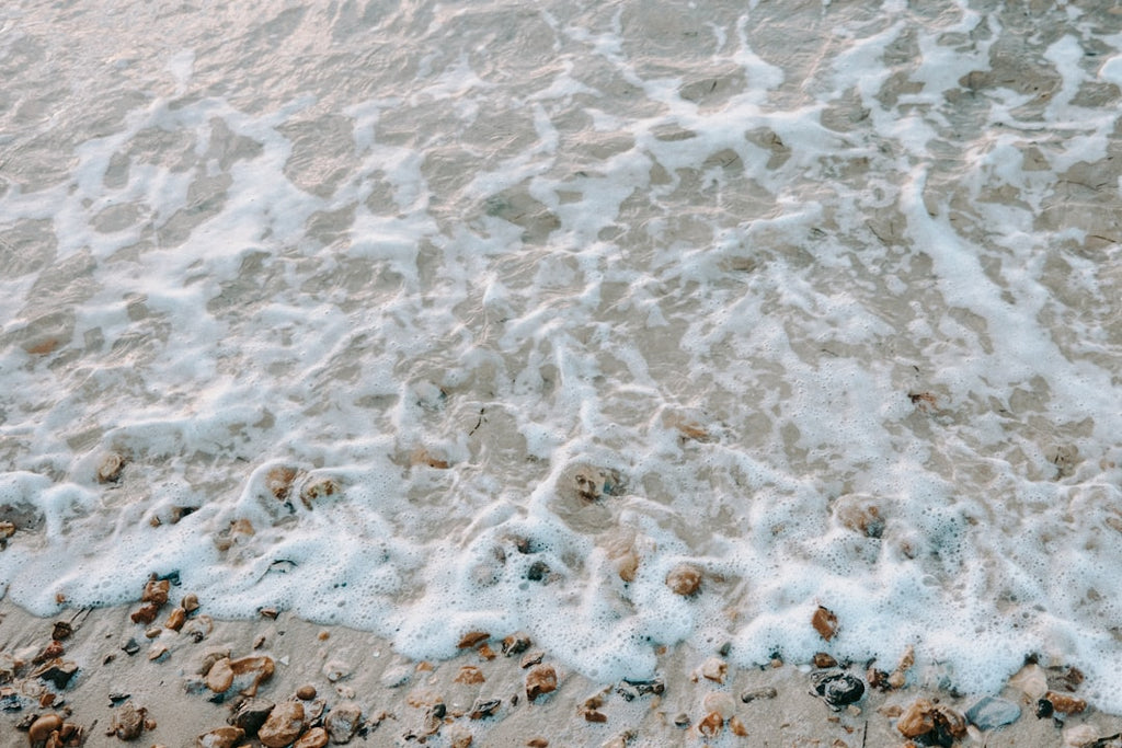 Oceanography Mirror wallpaper pattern — base photo: a sandy beach covered in lots of foamy water