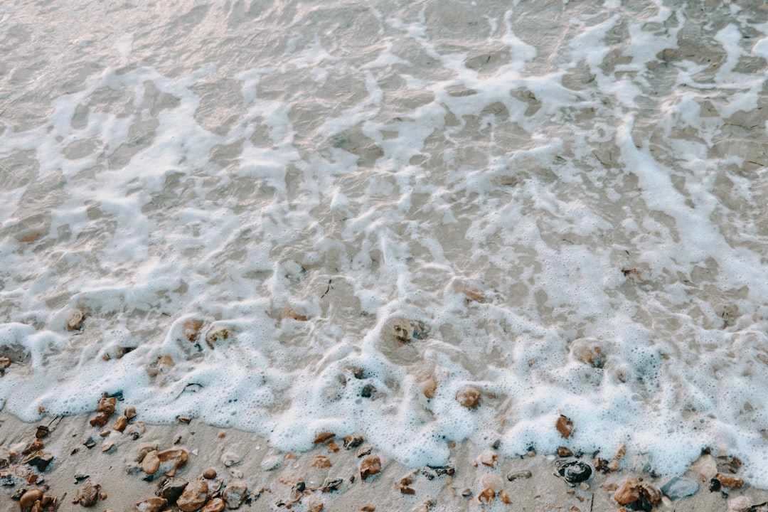 Oceanography Kaleidoscope wallpaper pattern — base photo: a sandy beach covered in lots of foamy water