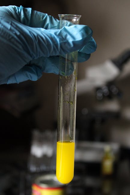 Seamless kaleidoscope wallpaper pattern — Biochemistry by wallpaper⁶ — base photo: Gloved hand holding a yellow liquid-filled test tube in a lab setting.