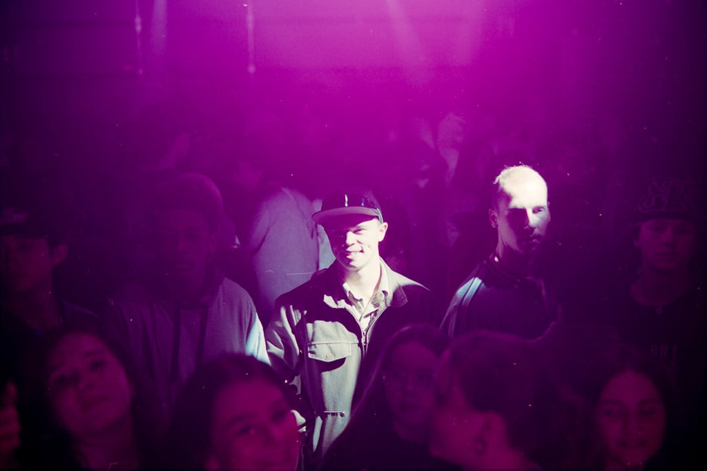 Emotions Wave wallpaper pattern — base photo: People gathered in a dimly lit, purple-lit room.