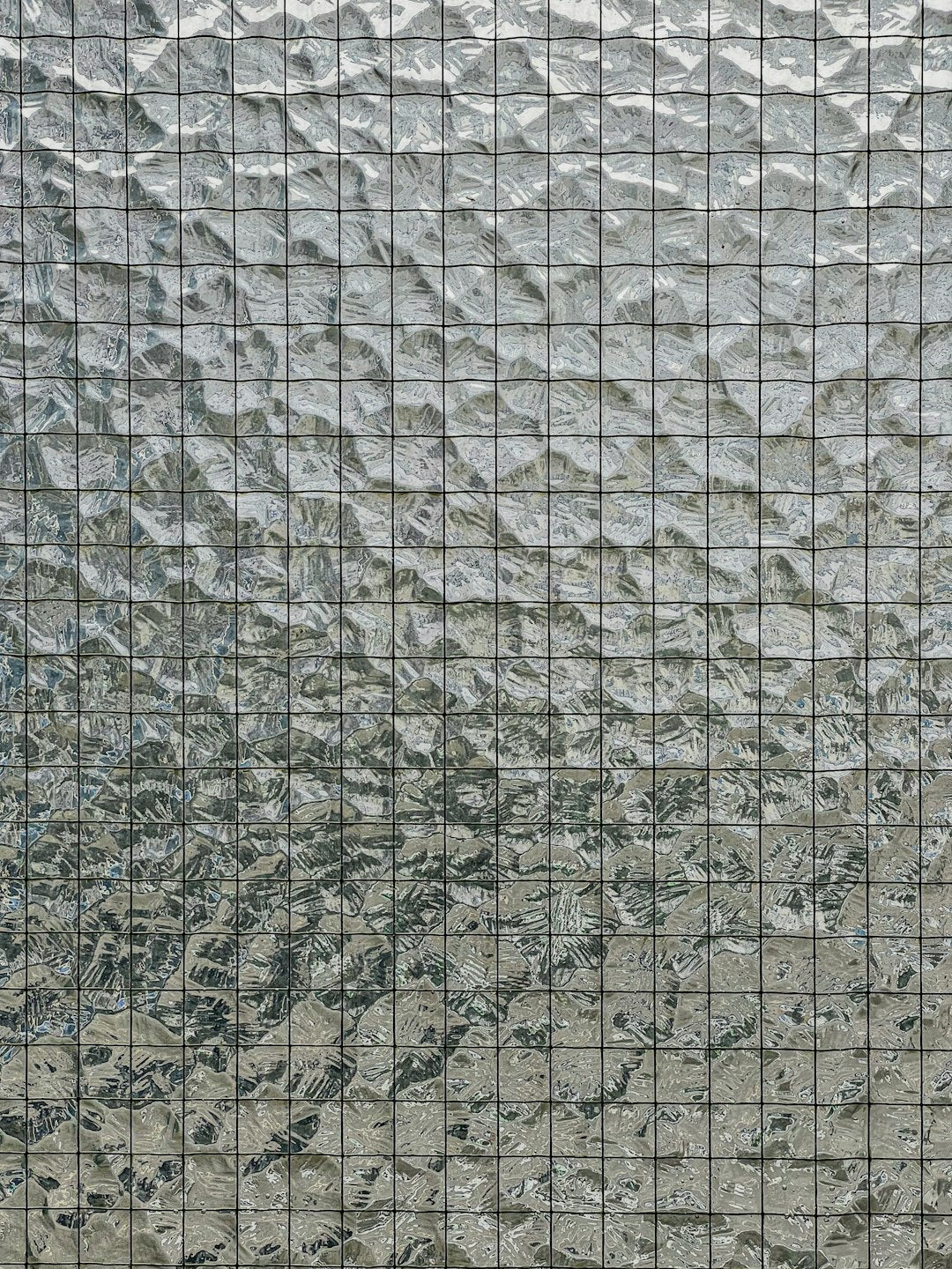 Seamless hex wallpaper pattern — Stained Glass by wallpaper⁶ — base photo: This image displays a close-up of a glass building facade with a distinctive textured pattern. The g