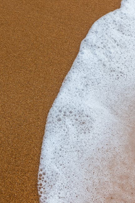 Oceanography Wave wallpaper pattern — base photo: Detailed view of ocean foam meeting sandy beach, capturing texture and contrast.