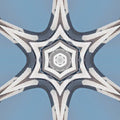 A radial kaleidoscope pattern featuring shades of blue and white glass panels in a symmetrical star-like formation.