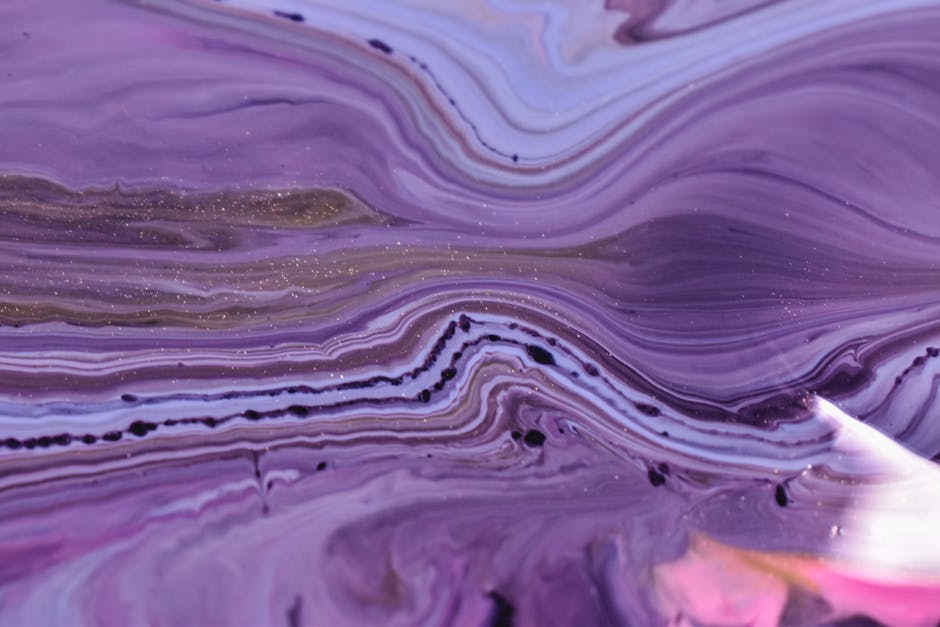 Abstract self-adhesive wallpaper featuring swirling blue and pink watercolor inks in a rotational pattern. — base photo: A close-up view of spilled blue and pink inks in water, captured mid-splatter. The colors flow and m