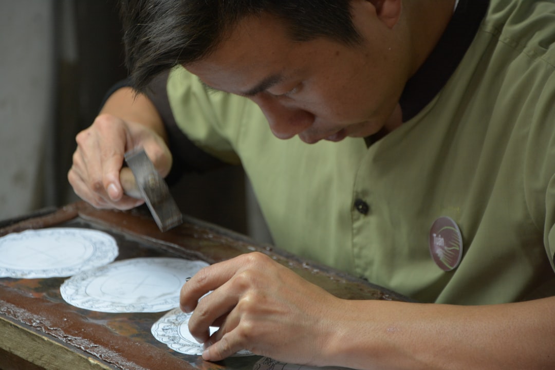 Portraits Kaleidoscope wallpaper pattern — base photo: A workman tapping a design with a hammer and point tool