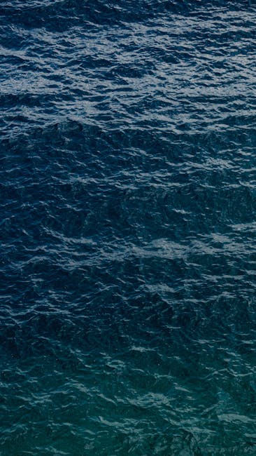 Oceanography Kaleidoscope wallpaper pattern — base photo: A tranquil view of wavy ocean water captured in a vertical format, showcasing its natural beauty.