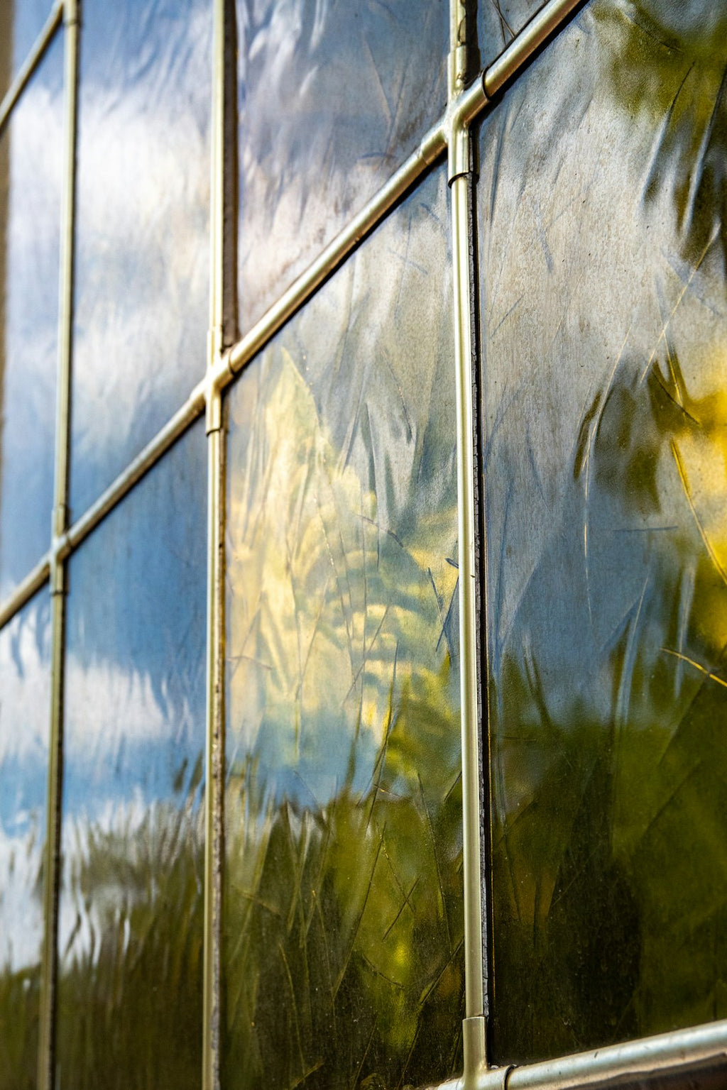 A mesmerizing kaleidoscope pattern inspired by leaded stained glass details, featuring geometric shapes and vibrant colors in a seamless repeat. — base photo: A close-up view of traditional leaded glass, showcasing the delicate interplay of colored glass segm