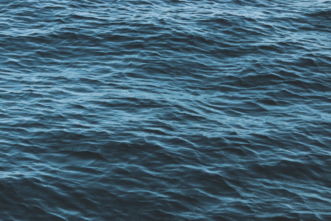 Oceanography Wave wallpaper pattern — base photo: a boat floating on top of a large body of water