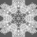 A dark, monochromatic wallpaper pattern showing a radial Kaleidoscope symmetry of 3D geometric prisms and sharp shards.