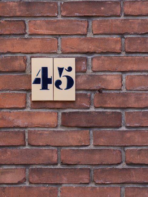 Seamless kaleidoscope wallpaper pattern — Arithmetic by wallpaper⁶ — base photo: Close-up of house number 45 displayed on a classic red brick exterior wall.