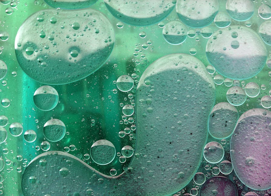 Abstract mirror pattern of green oil and water bubbles, resembling a scientific microscopic view, on wallpaper. — base photo: A macro photograph captures the dynamic, abstract texture of green oil and water bubbles. The immisc
