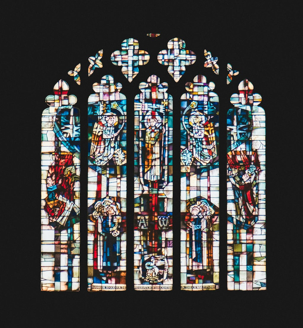 A radial Kaleidoscope pattern of blue and amber stained glass fragments with leaded borders in a complex geometric repeat. — base photo: A capture by K. Mitch Hodge of L.C. Evetts' stained-glass window, depicting the Ascension of Jesus, 