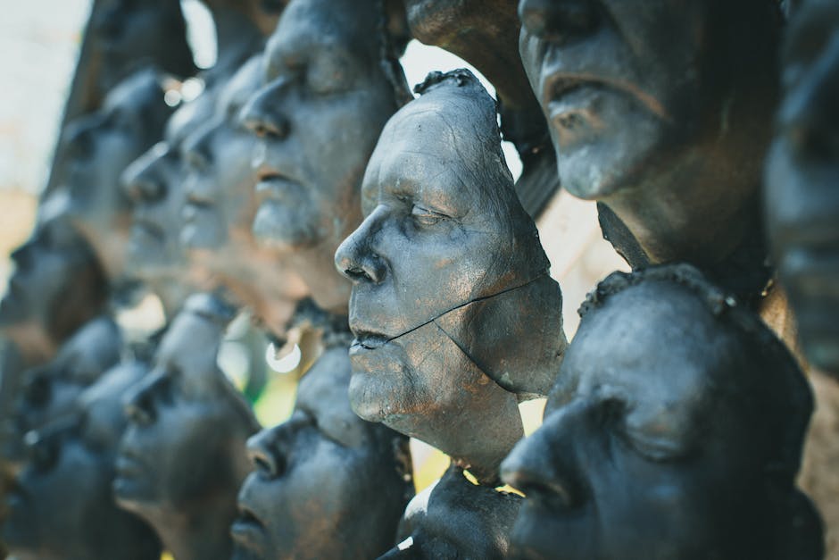 3D Rotation wallpaper pattern — base photo: Close-up of bronze sculptures showcasing abstract human faces with a cracked surface.