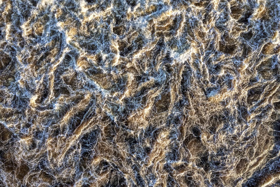 Biology Wave wallpaper pattern — base photo: Aerial abstract image showcasing rugged, craggy water texture with a dynamic pattern.