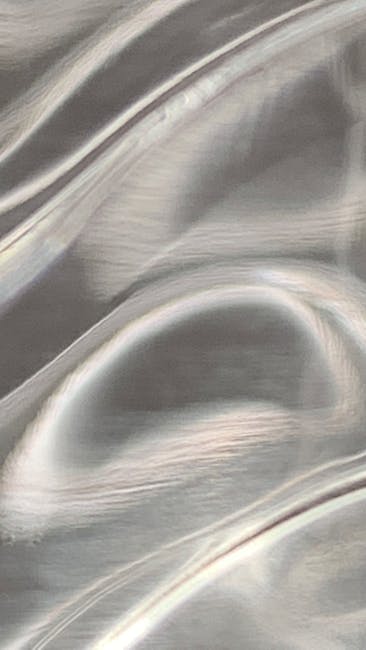 Seamless mirror wallpaper pattern — Glitch by wallpaper⁶ — base photo: Close-up of a smooth, metallic texture with flowing patterns in neutral tones.