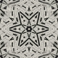 A monochromatic Op-Art pattern with complex Kaleidoscope symmetry forming a star-like crystalline structure with sharp black and white lines.