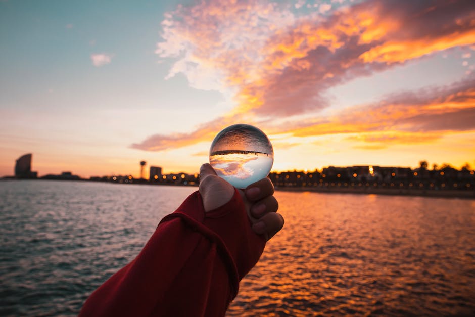 Kaleidoscopic pattern featuring vibrant sunset colors, originating from a reflection in a glass sphere, arranged in repeating symmetrical segments. — base photo: A captivating image of a Barcelona sunset, with its vibrant colors precisely reflected within the cu