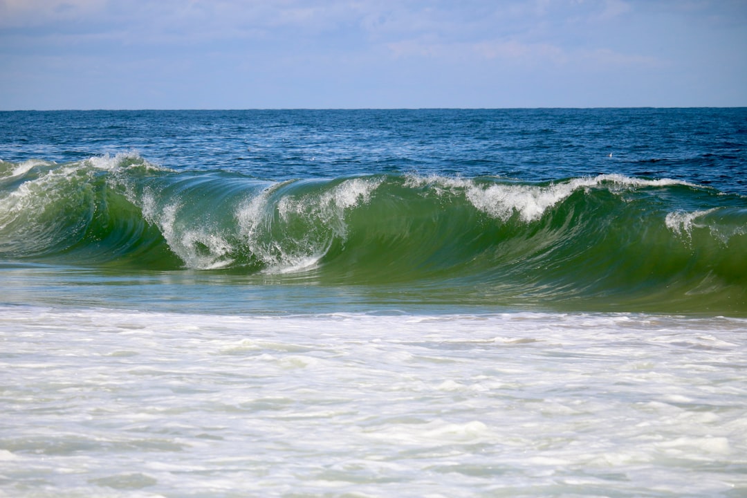Oceanography Wave wallpaper pattern — base photo: A large green wave crashes on the shore.