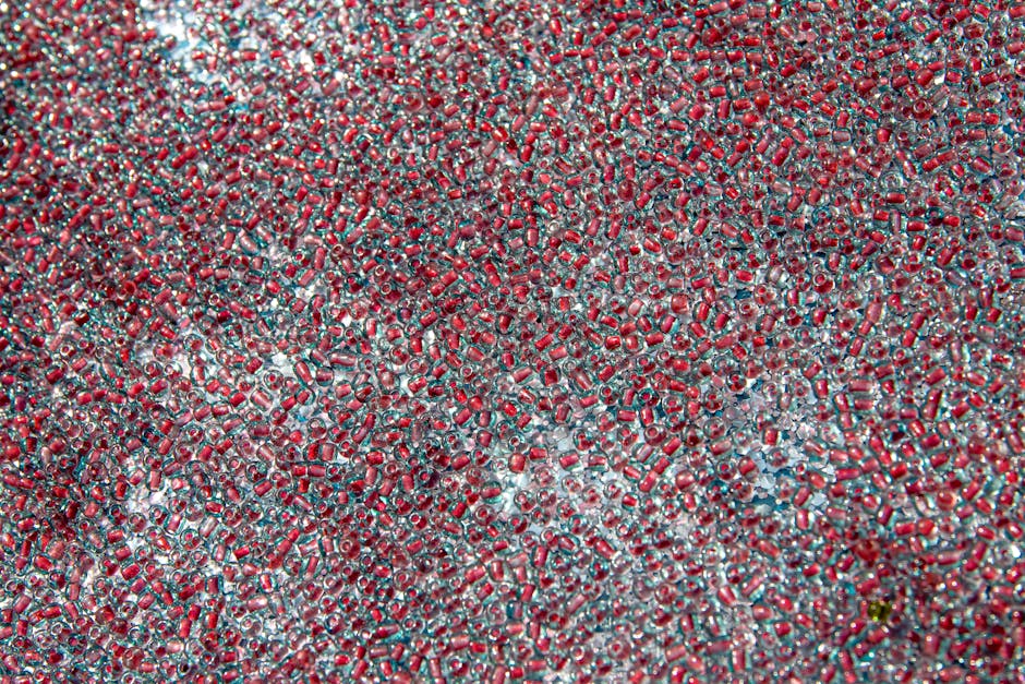 Chemistry Hexagon wallpaper pattern — base photo: An intricate pattern of red and clear glass beads creating a textured, colorful background.