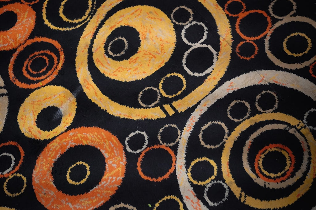 Abstract wallpaper pattern of interlocking orange and yellow Borromean Rings forming a wave on a black background, inspired by Topology. — base photo: Abstract composition featuring three interlocking Borromean Rings, rendered in vibrant orange and ye