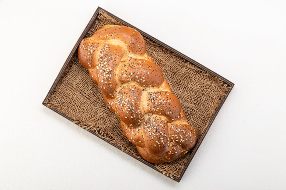 Seamless mirror wallpaper pattern — Biochemistry by wallpaper⁶ — base photo: Overhead shot of a golden braided challah bread with sesame seeds, presented on a rustic woven tray.