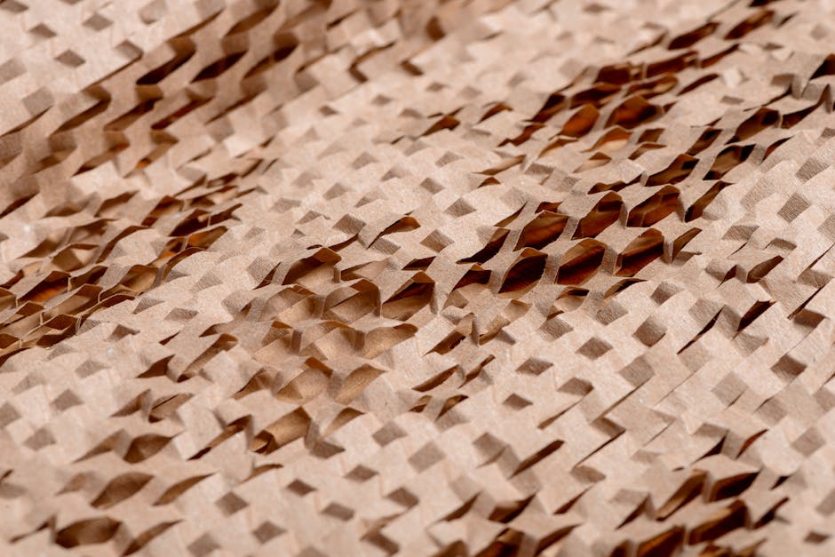 Close-up of textured brown paper in a geometric honeycomb pattern with mirror symmetry, inspired by origami folds. — base photo: A close-up captures the meticulous detail of a brown paper honeycomb. Layers of precisely cut and fo