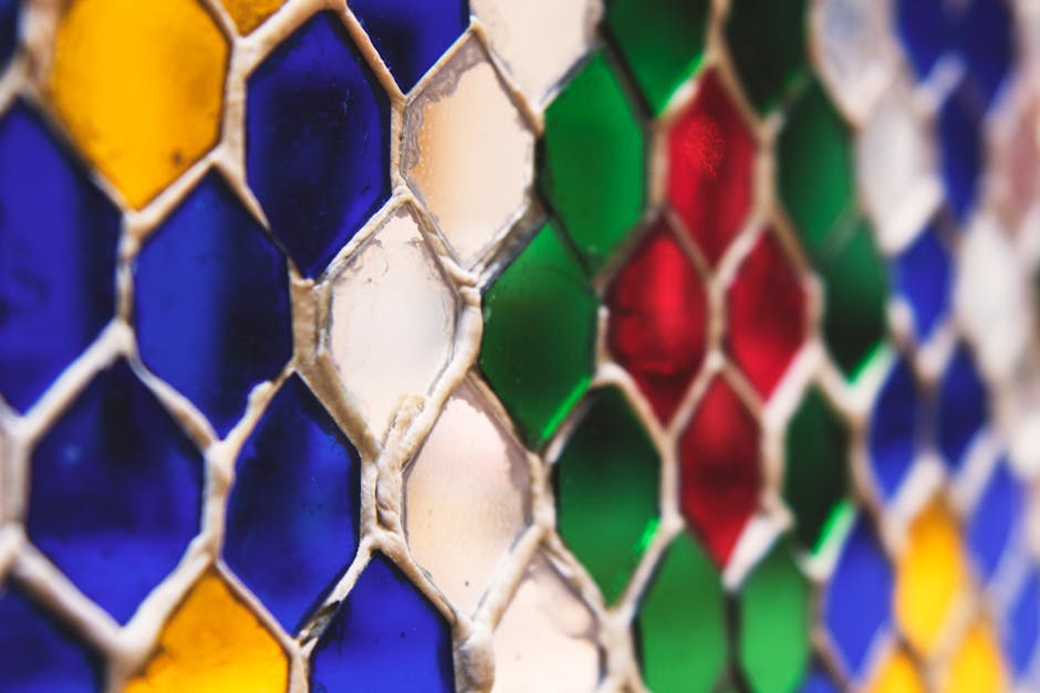 Seamless kaleidoscope wallpaper pattern — Geometry by wallpaper⁶ — base photo: Close-up of a colorful honeycomb stained glass pattern with vivid red, green, blue, and yellow hues.