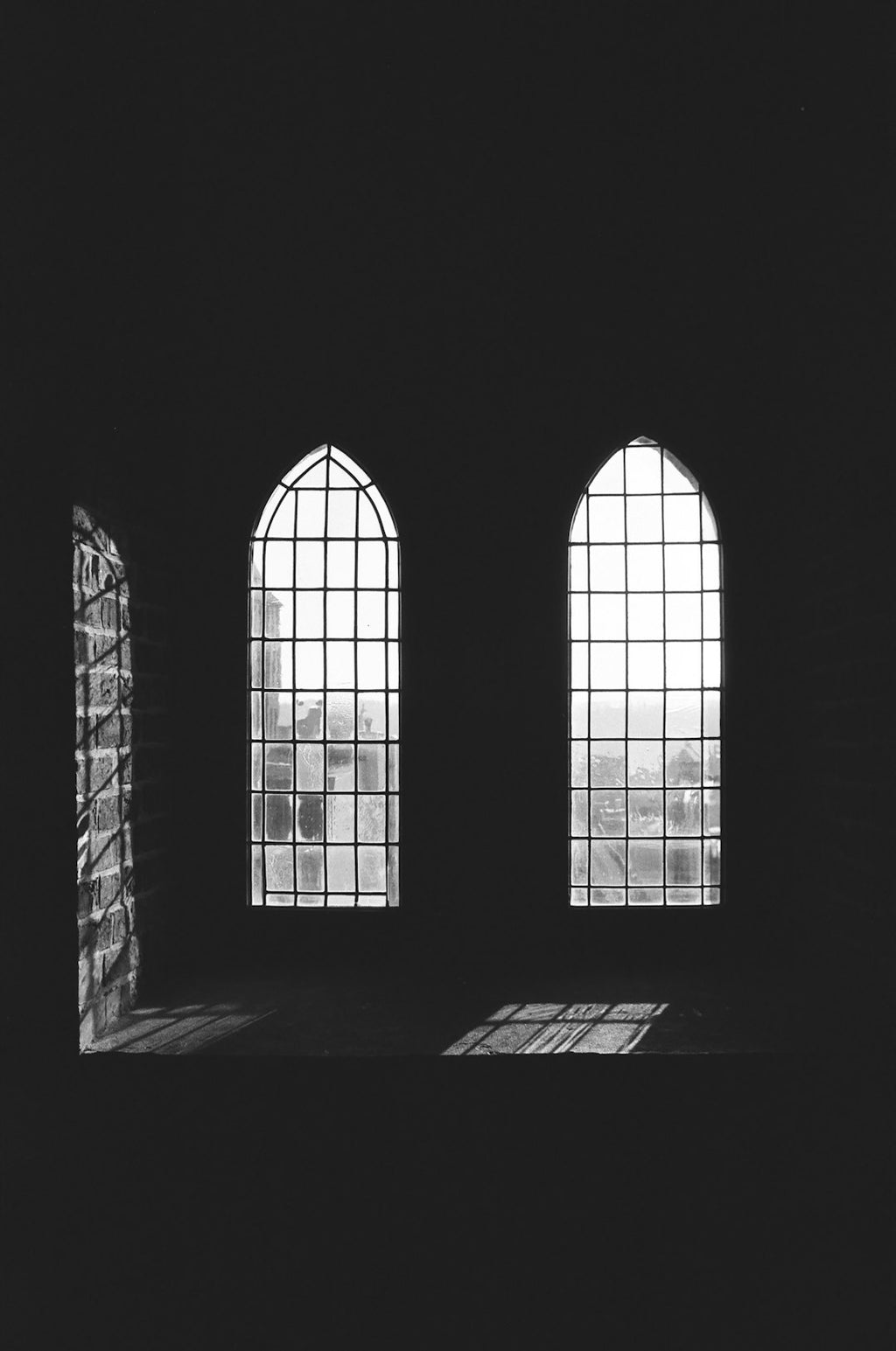 Intricate stained glass pattern with kaleidoscope symmetry, featuring geometric shapes and high contrast light and shadow. — base photo: A sun-drenched facade of Toruń, captured with a Minolta X-300 and Agfa APX 100 film. The image featu