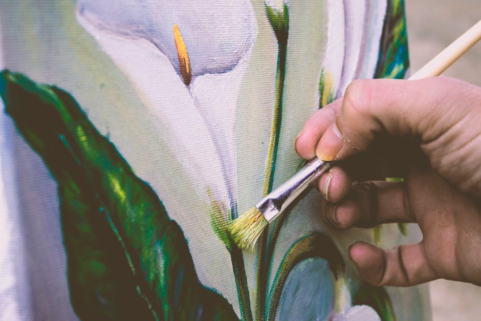 Botanics Hexagon wallpaper pattern — base photo: Close-up view of an artist painting a floral design on canvas using a brush.