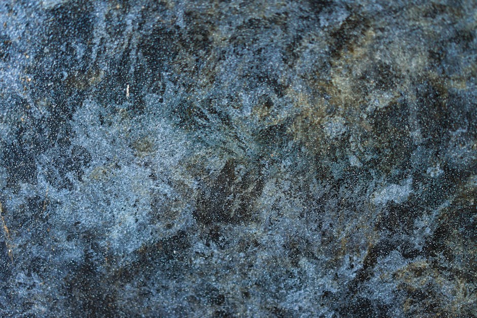 Abstract Rotation wallpaper pattern — base photo: Detailed close-up of a rough, textured stone surface with blue and gray tones.