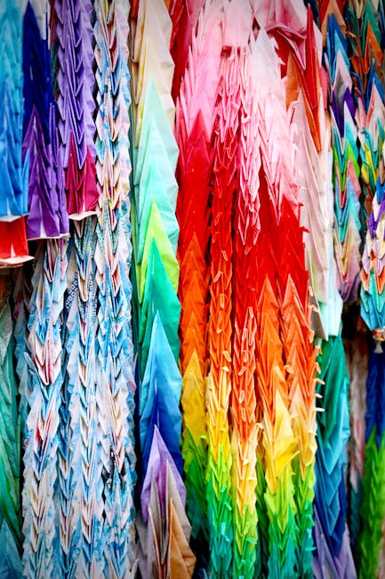 A seamless pattern of colorful origami cranes arranged with mirror symmetry, creating a visually striking and intricate design. — base photo: A vibrant collection of traditional Japanese origami cranes, meticulously folded and suspended. Thei