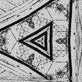 Close-up of hexagonal leaded glass pattern in black and white, inspired by Gothic architecture, in a stone window frame.