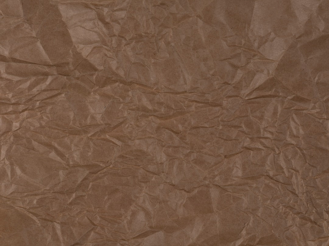 Close-up of an origami paper folding texture in a diamond pattern repeat, creating geometric folds and subtle crumples. — base photo: A close-up shot of meticulously folded paper exhibiting a delicate crumpled texture. The lighting hi