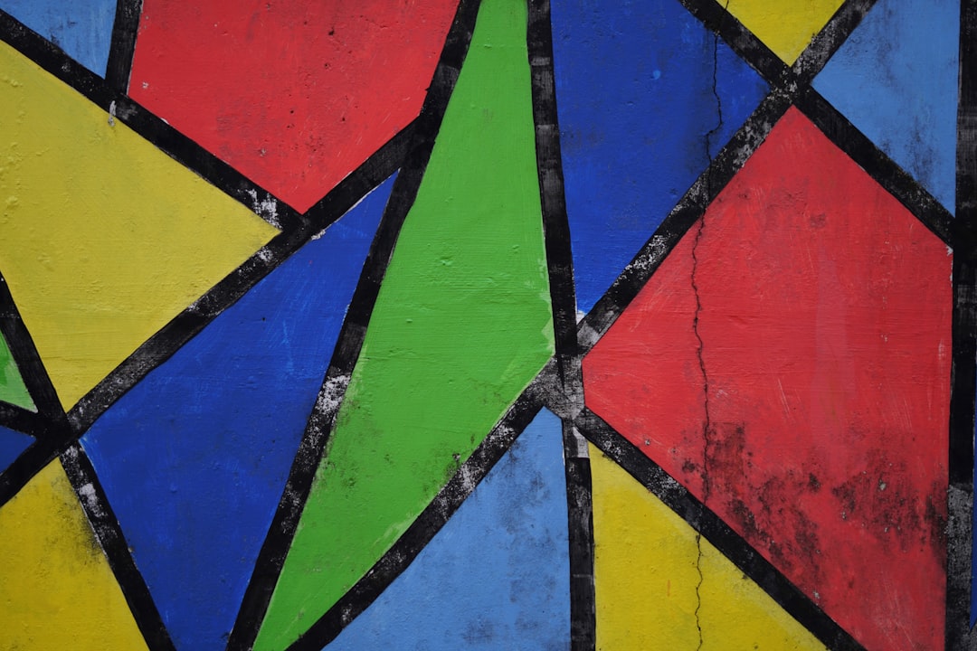 A vibrant, symmetrical kaleidoscope pattern created from segments of colourful stained glass, featuring leaded glass-inspired lines. — base photo: A close-up view of vibrant, richly coloured glass panes, hinting at the intricate leaded lines and t