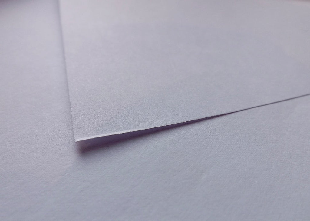 Intricate origami folds with mirror symmetry on wallpaper, showcasing wet folding paper techniques. — base photo: A close-up capture of intricately folded paper, showcasing the subtle textures and sharp creases ach