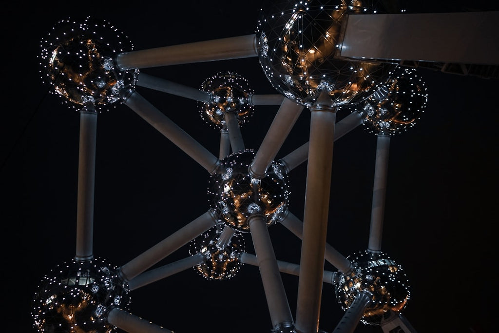 Seamless diamond symmetry pattern inspired by molecular physics and the Atomium at night. — base photo: The Atomium in Brussels illuminated at night, with its distinct spherical structures and connecting 