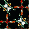 A repeating diamond pattern featuring dark silhouettes against vibrant stained glass colors in a rhythmic, geometric layout.