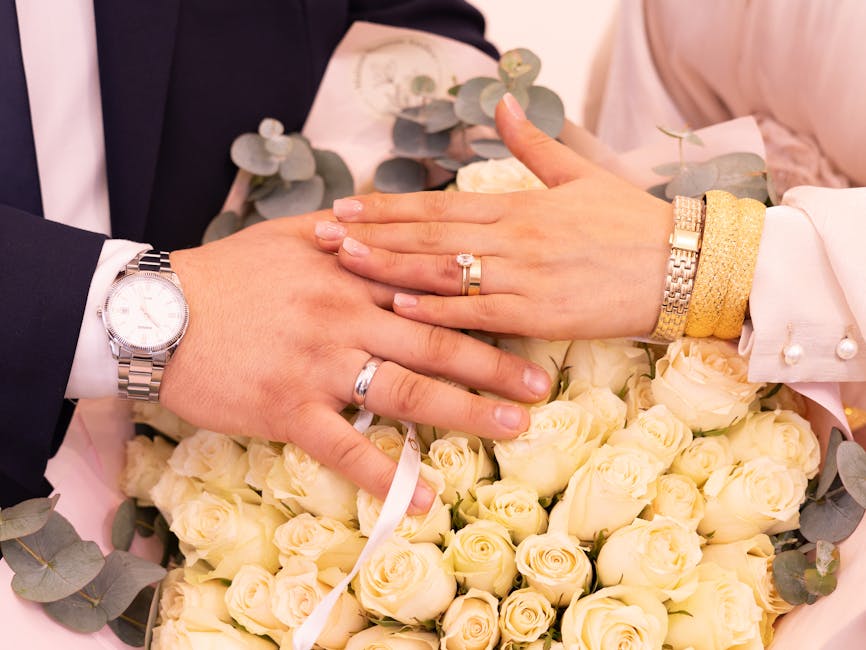A seamless repeat pattern of Borromean Rings arranged in a symmetrical kaleidoscope on a white background, symbolizing topological connections. — base photo: A tender close-up captures intertwined wedding bands resting on a lush bouquet of pristine white ros