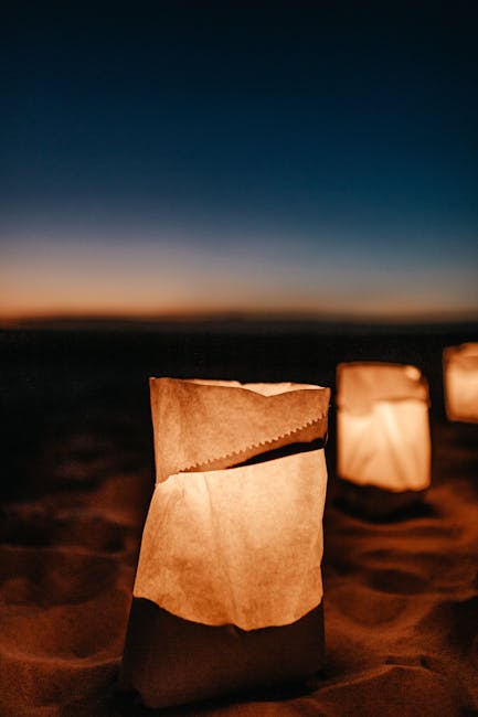 Seamless mirror wallpaper pattern — Origami by wallpaper⁶ — base photo: Glowing paper lanterns placed on a beach at twilight, creating a warm and serene atmosphere.