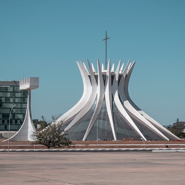 A radial kaleidoscope pattern featuring shades of blue and white glass panels in a symmetrical star-like formation. — base photo: A high-angle architectural shot of the stained glass panels and white concrete ribs inside the Cathe