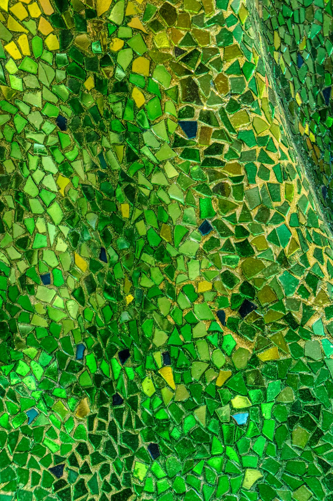 Close-up of a green and yellow stained glass mosaic tile in a repeating hex pattern, evoking leaded glass artistry. — base photo: A detailed macro view captures the textured surface of a glass mosaic tile, showcasing warm yellow a