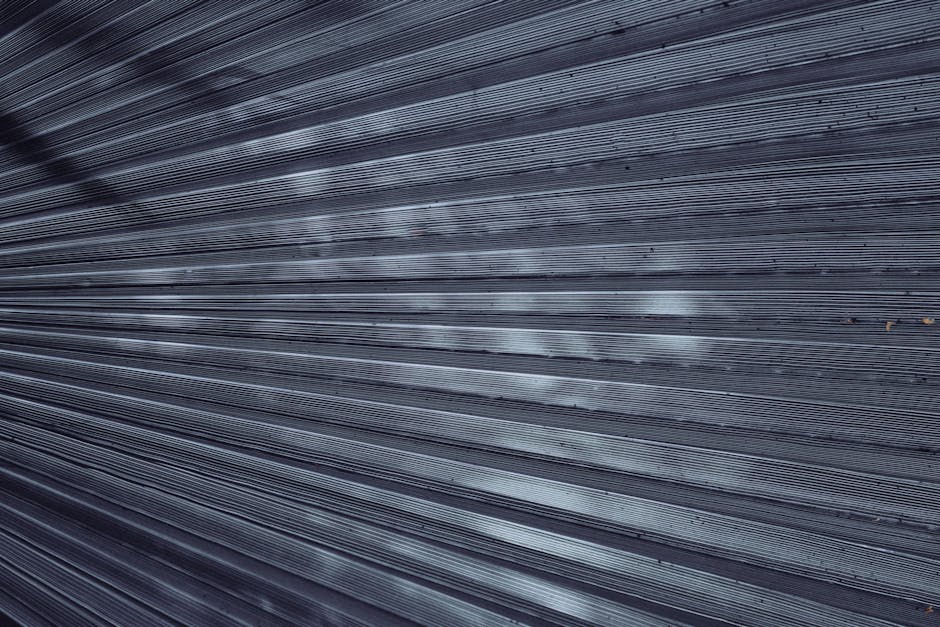 Close-up of textured metal surface with grayscale lines arranged in a brick pattern, inspired by AI transformer technology. — base photo: A highly detailed, close-up photograph of a textured metallic surface. The texture is rendered in cr
