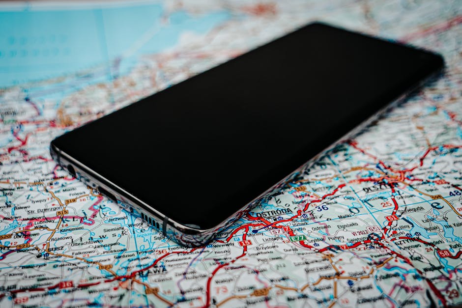 Seamless brick wallpaper pattern — Cartography by wallpaper⁶ — base photo: Close-up of a smartphone placed on a detailed road map of Poland, emphasizing travel and technology.