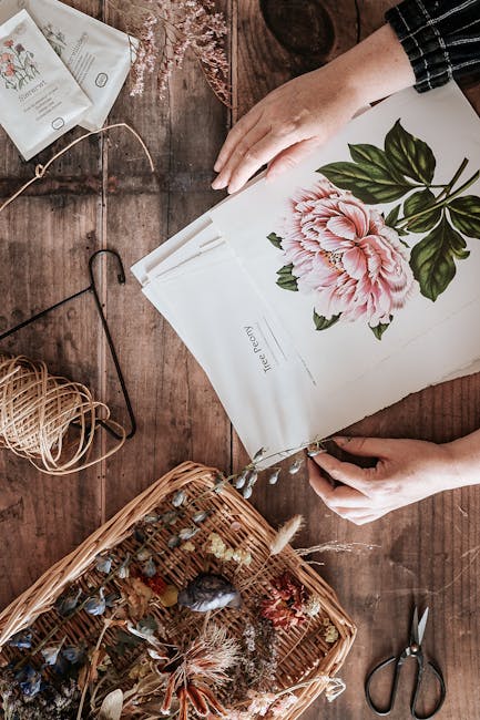 Close-up of a botanical illustration pattern with hexagonal symmetry on a wall, showcasing floral details and green hues. — base photo: A top-down view captures hands thoughtfully arranging a delicate floral artwork featuring dried flow