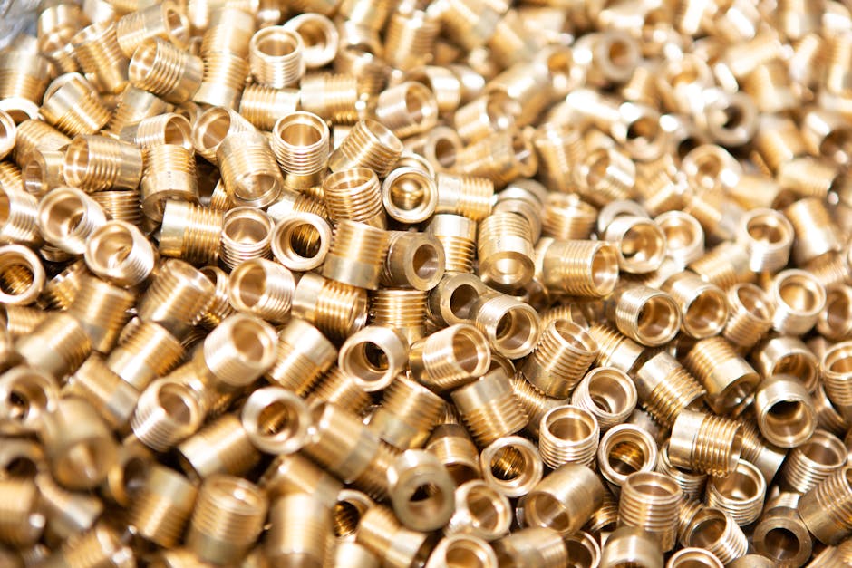Algorithms Hexagon wallpaper pattern — base photo: A detailed close-up of a pile of brass screws and nuts with a golden metallic finish.